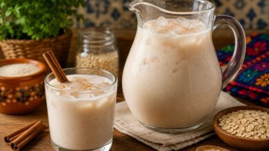 Jarra y vaso con agua de horchata con avena, hielo y canela