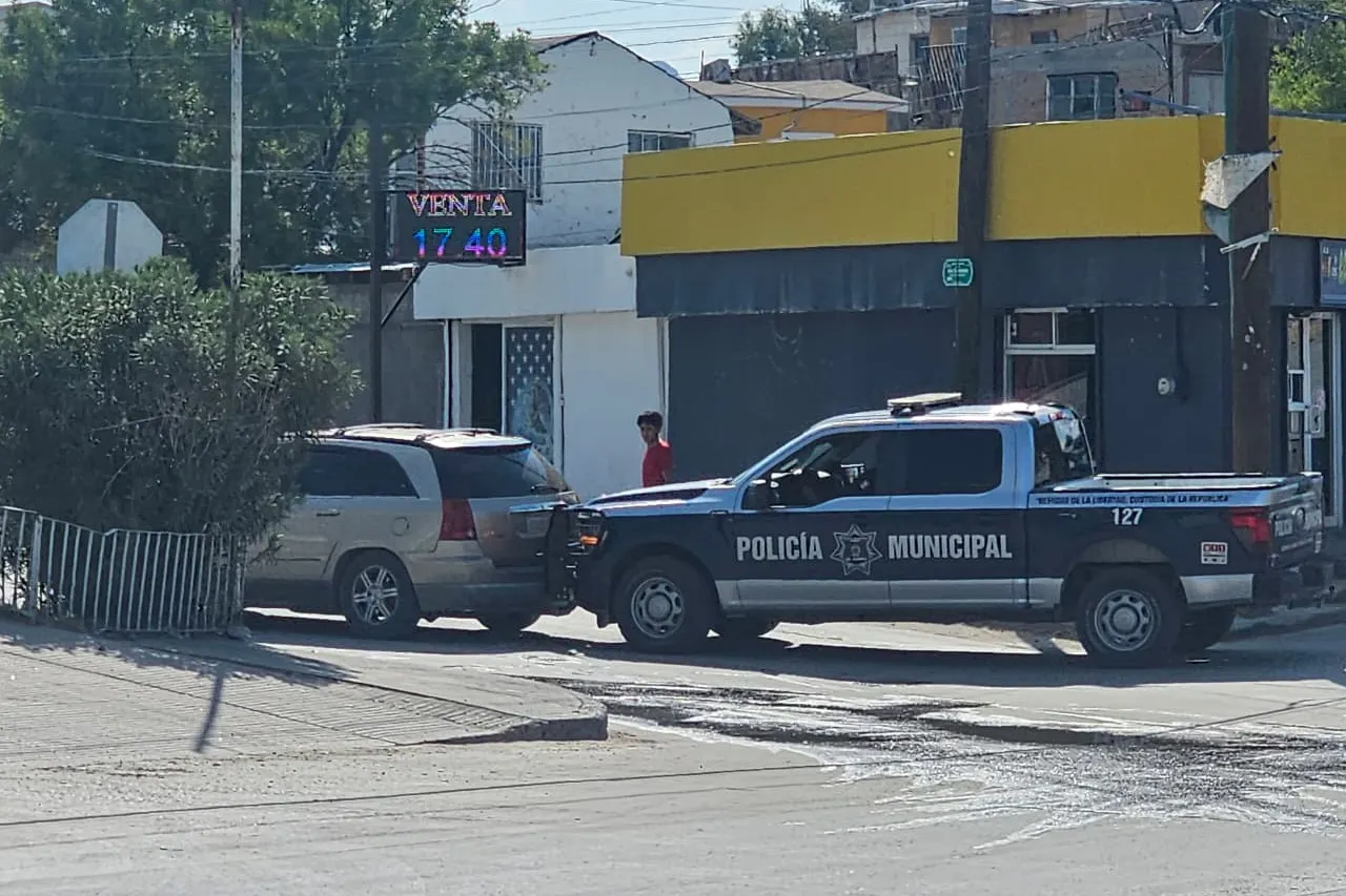 Policías municipales apoyan a una camioneta varada para llegar a una gasolinera en Ciudad Juárez