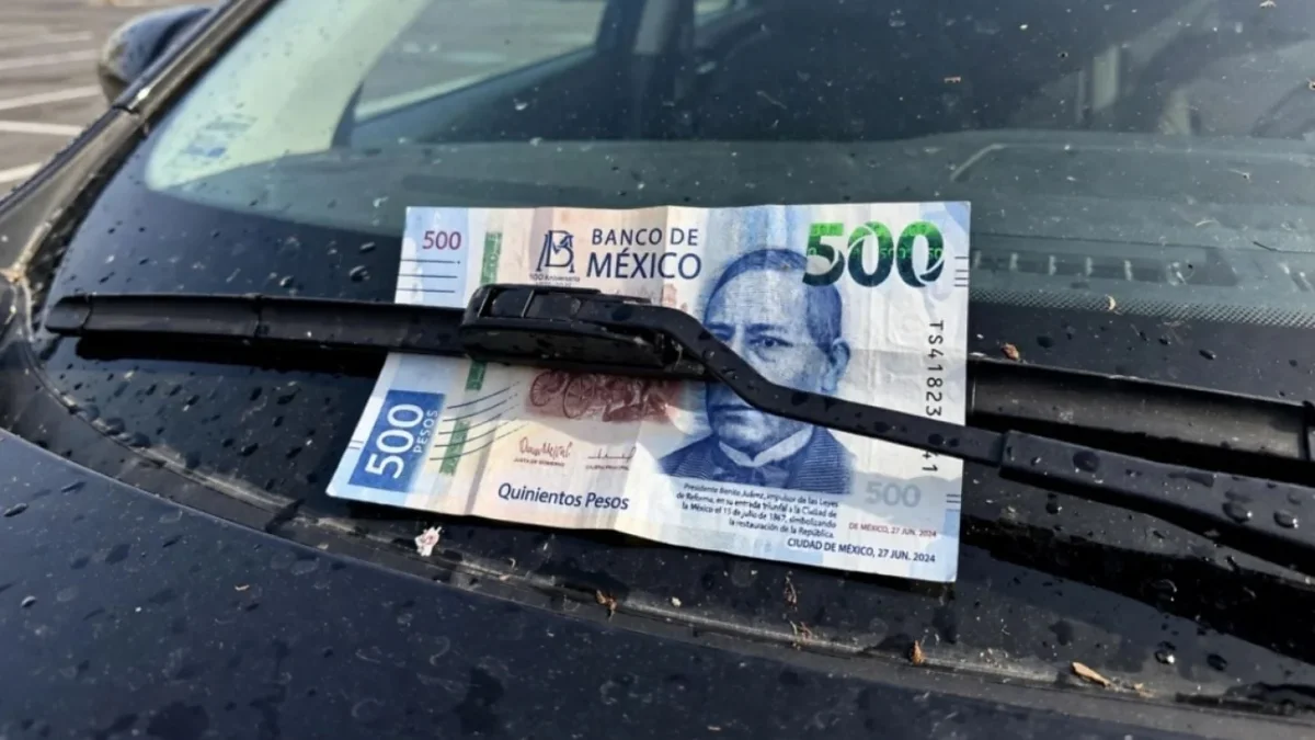 Billete colocado en el parabrisas de un automóvil como posible distracción