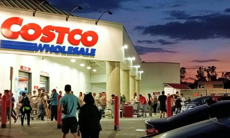 Empleado de Costco México revisa un ticket de compra a la salida de una tienda