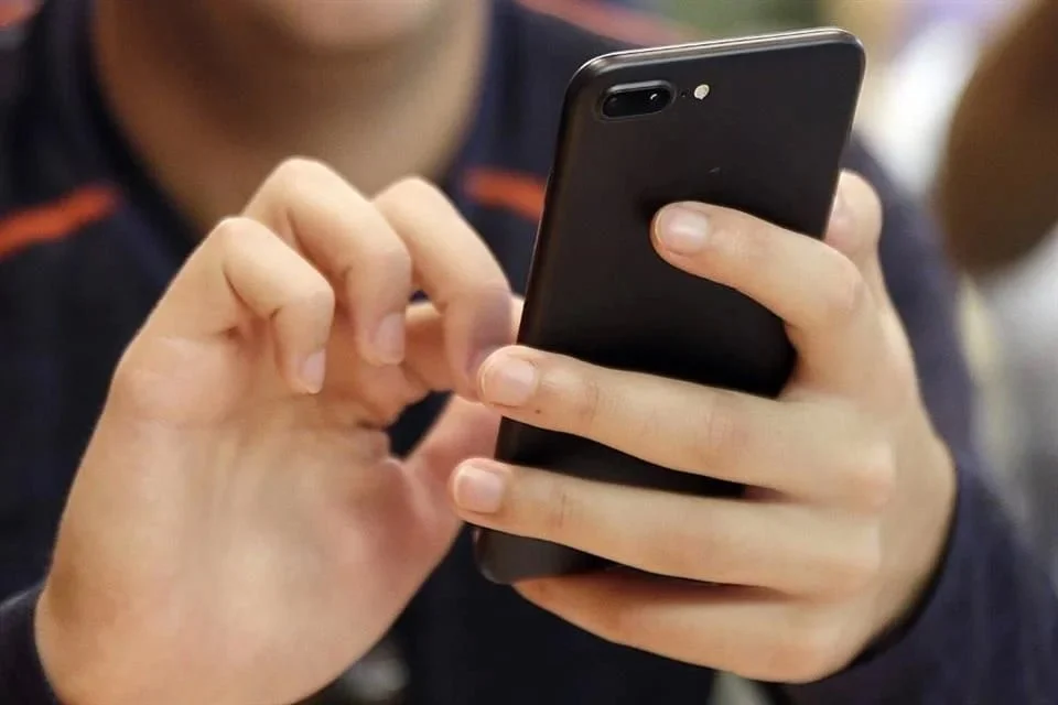 Persona utiliza un teléfono celular para registrar su número móvil