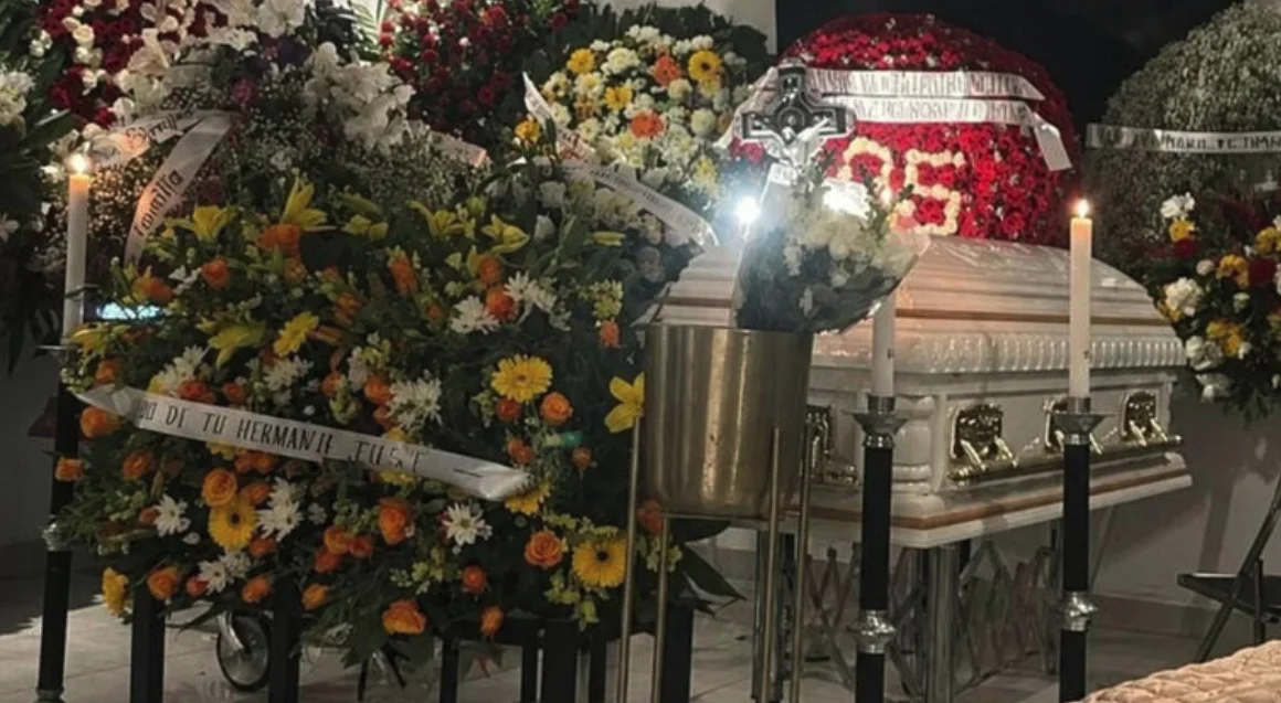 Féretro blanco y arreglos florales durante un servicio funerario en Los Reyes de Salgado, Michoacán