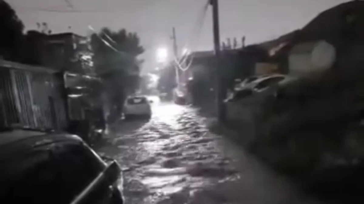 Calle cubierta por una fuerte corriente de agua en la colonia La Presa de Ciudad Juárez