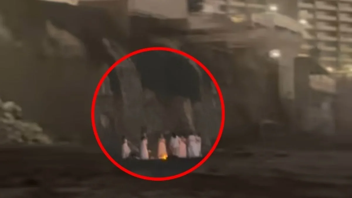 Ocho mujeres vestidas de blanco alrededor de una fogata frente al mar durante la noche
