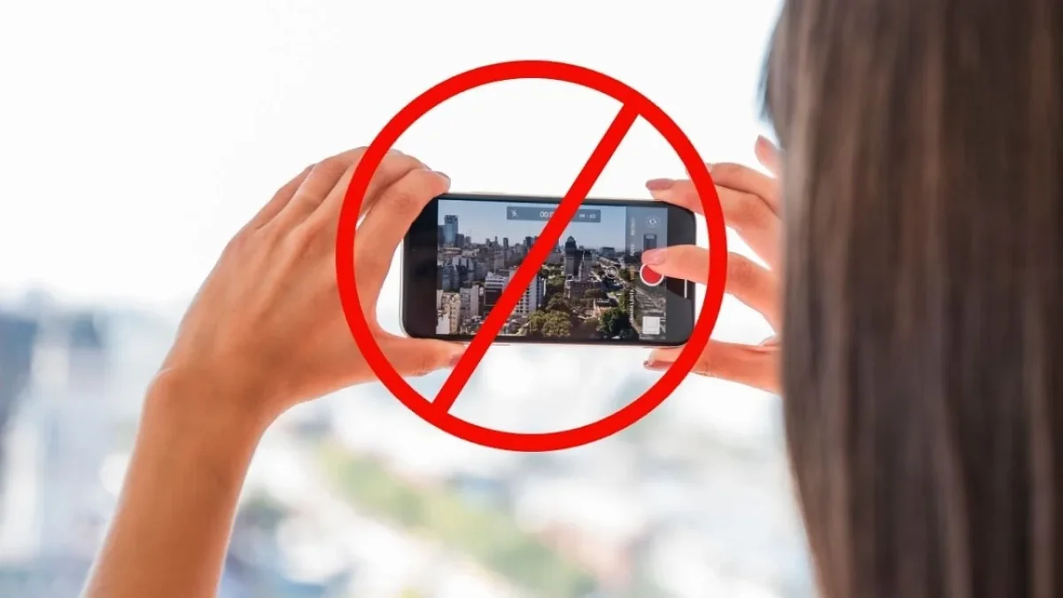 Teléfono celular con una conversación de WhatsApp sobre fotos de vecinos sin permiso