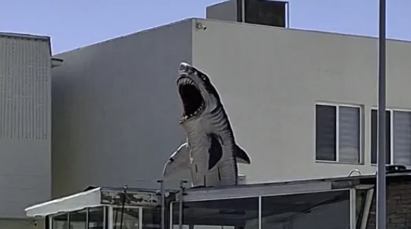 Casa de Ciudad Juárez decorada para Halloween con un dinosaurio, un tiburón y luces