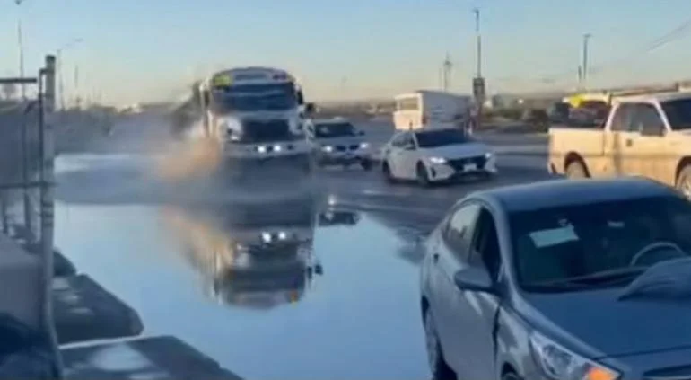 Camión de transporte público pasa por megabache inundado en el bulevar Talamás