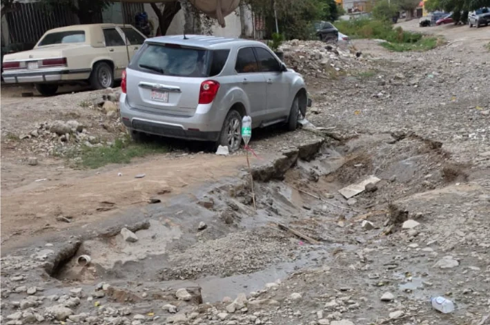 Calle dañada por las lluvias en Ciudad Juárez