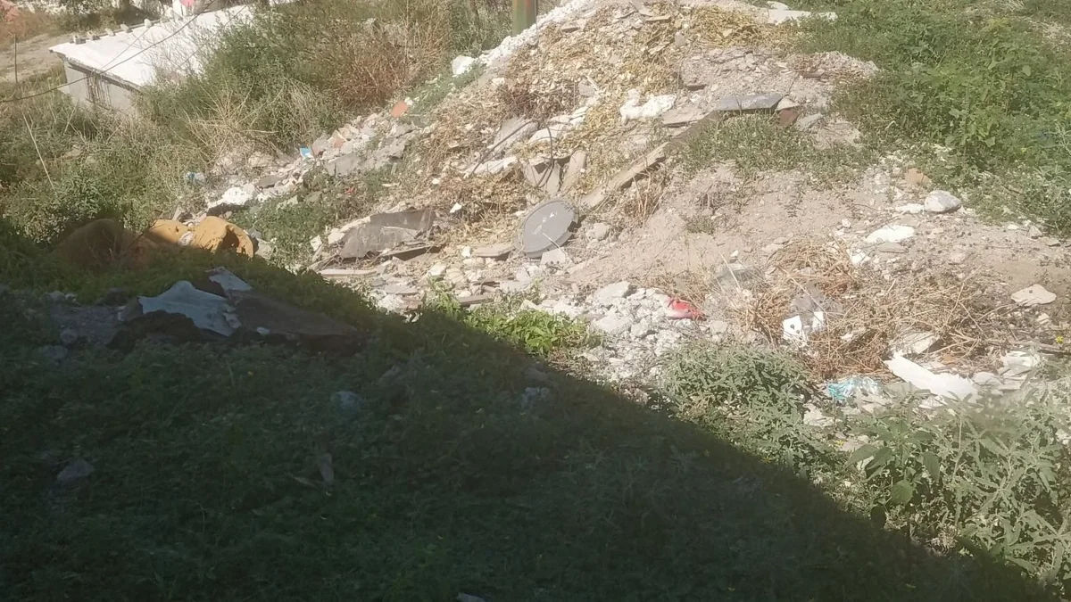 Basura y escombro acumulados junto a una vivienda en Hospital y Cocotero de Ciudad Juárez
