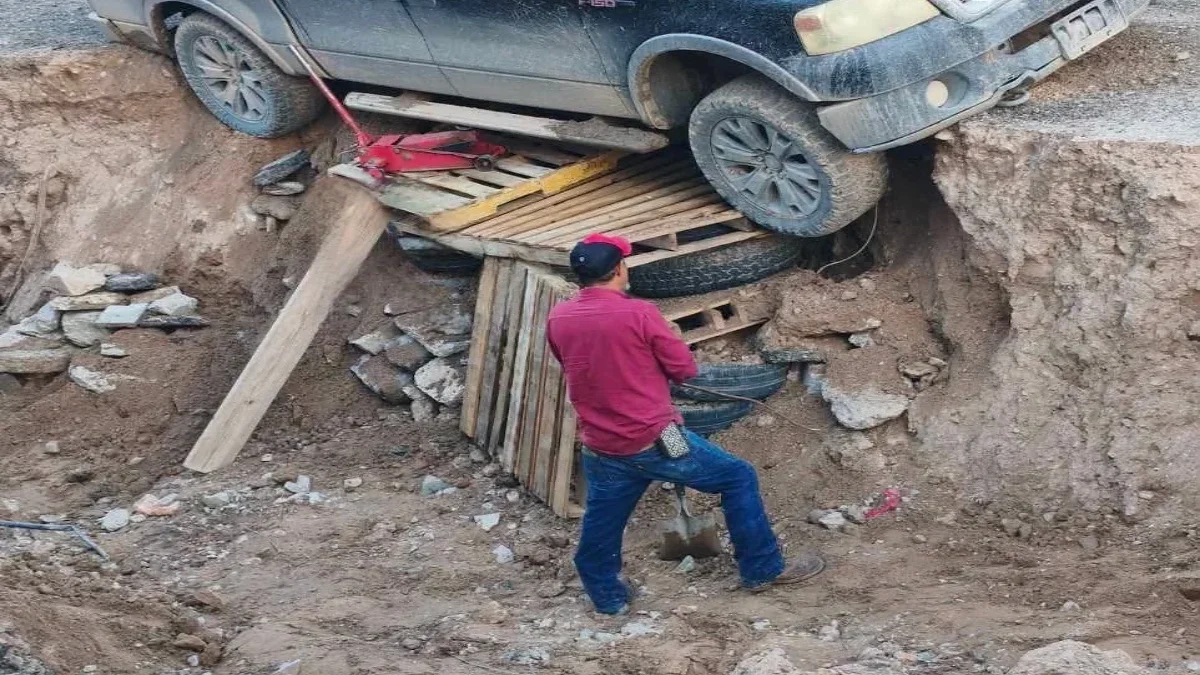 Camioneta Ford F-150 apuntalada con tarimas y llantas junto a un socavón en Ciudad Juárez