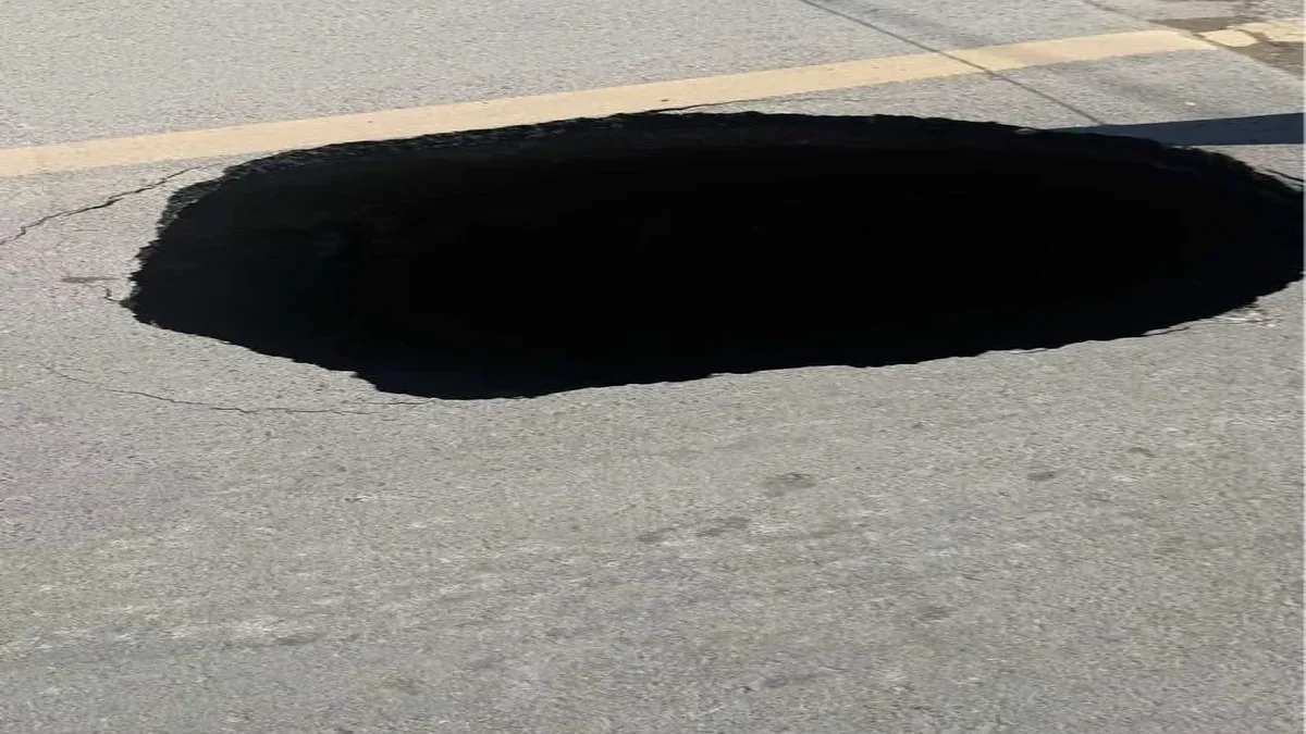 Socavón de gran tamaño abierto sobre el pavimento de la calle Capulín en Ciudad Juárez