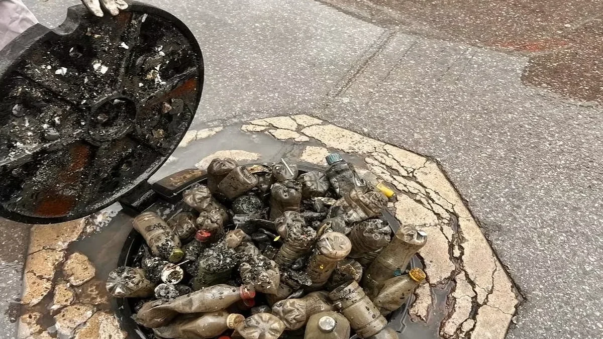 Botellas de plástico y residuos acumulados en un registro de drenaje de Ciudad Juárez