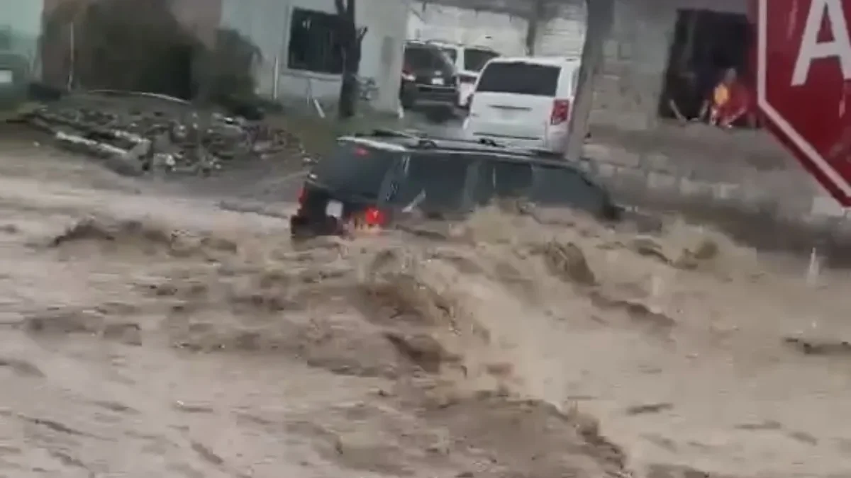 Jeep Grand Cherokee verde arrastrada por la corriente de un arroyo en Ciudad Juárez