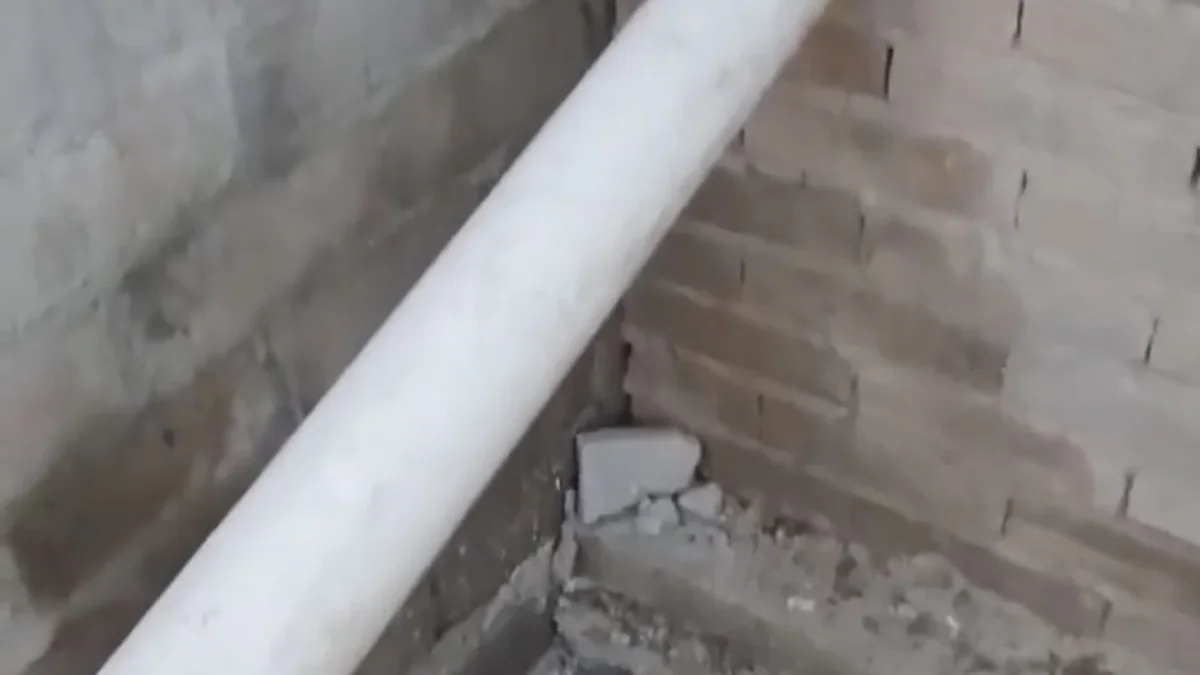 Tubería de drenaje atraviesa una barda hacia un patio vecino en Ciudad Juárez