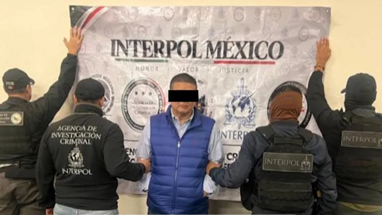Elementos federales frente a logotipos de Interpol México durante la detención de César Jáuregui