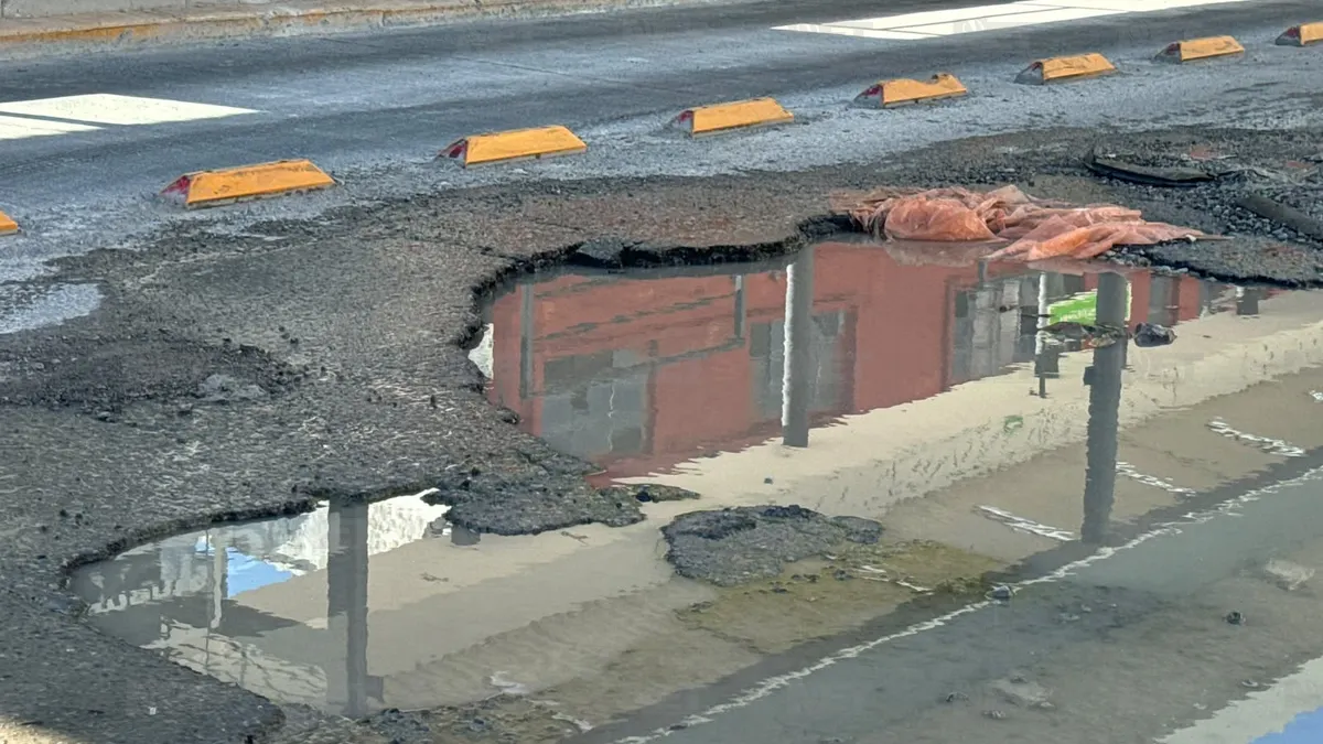 Agua acumulada sobre tres baches en la calle Manuel Bernal de Ciudad Juárez