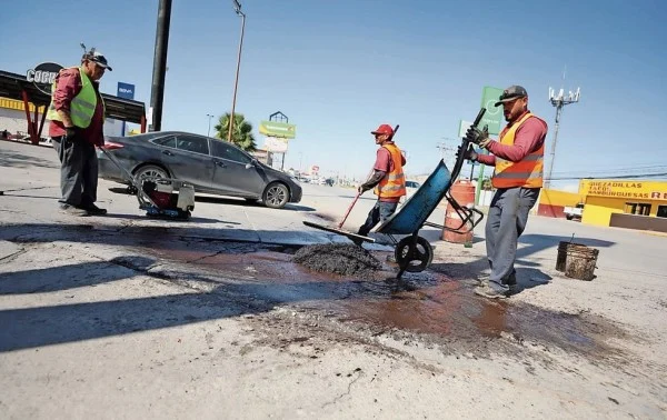 Cuadrilla municipal realiza trabajos de bacheo en una avenida de Ciudad Juárez
