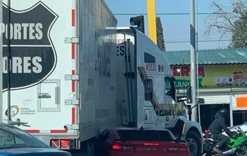 Camaro rojo atorado debajo de la caja de un tráiler en Óscar Flores y Montes Urales
