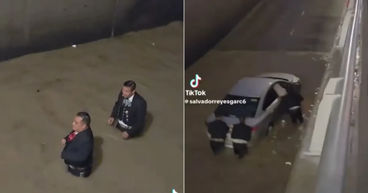 Mariachis empujan un vehículo varado durante una inundación en Ciudad Juárez