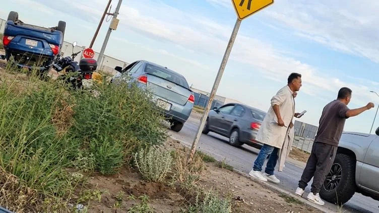 Automóvil sedán azul volcado frente a la empresa Inventec en Ciudad Juárez
